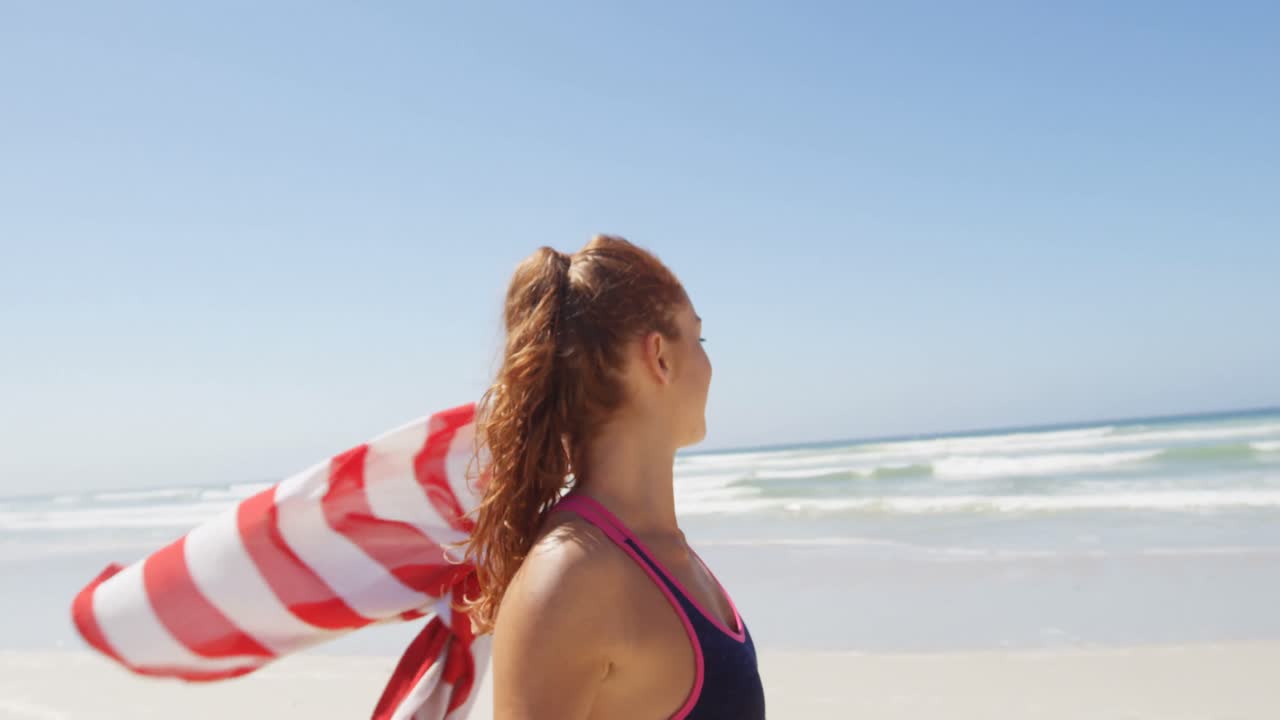 해변 4k에서 미국  ⁇ 발을 흔들고 바 ⁇ 가에 서 있는 여자