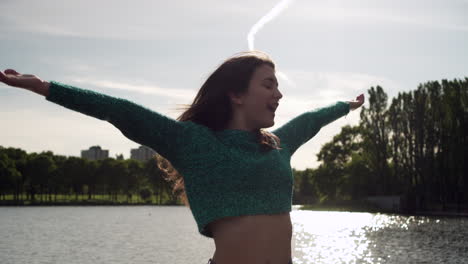 hermosa mujer italiana con los brazos levantados mirando la vista del atardecer sobre el lago