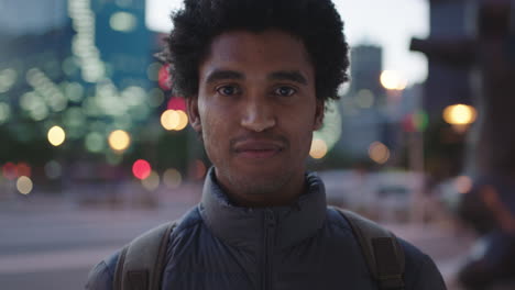 portrait of handsome mixed race man smiling wearing cozy jacket enjoying urban evening in city