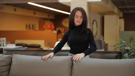 a woman in a store chooses a new sofa in a store a woman in a store chooses a new sofa in a store