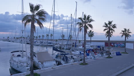 Timelapse-of-yachts-parked-at-the-dock-white-dramatic-sun-rises-and-breaks-through-the-clouds