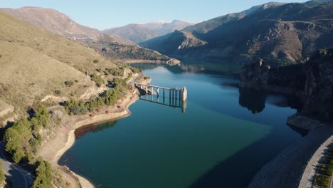 drone flight over the canales reservoir in güéjar sierra nevada in spain shows the high mountains and the beautiful blue water