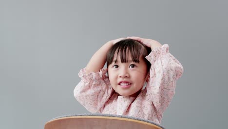 카메라를 보고 머리에 손을 얹은 아이