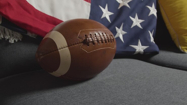 lounge zu hause einer person, die sich im fernsehen ein american-football-spiel mit der sternenbanner-flagge 3 ansieht