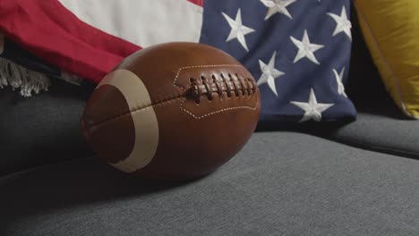 lounge at home of person watching american football game on tv with stars and stripes flag 3