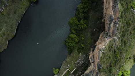 Griffon-Vulture-Flying-Over-The-Duraton-River-With-Steep-Gorge-Within-Hoces-del-Río-Duraton-Natural-Park