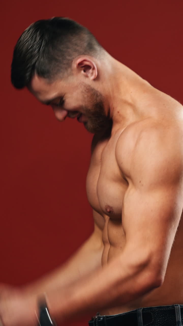 Male flexing his muscles. Muscular model young man on background. Vertical video