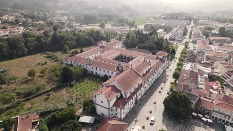 Luftschwenk-über-Der-Abtei-Von-Arouca-Und-Eine-Gerade-Straße-Hinunter-Auf-Die-Avenida-25-De-Abril,-Portugal