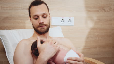 padre sosteniendo a un recién nacido en el hospital