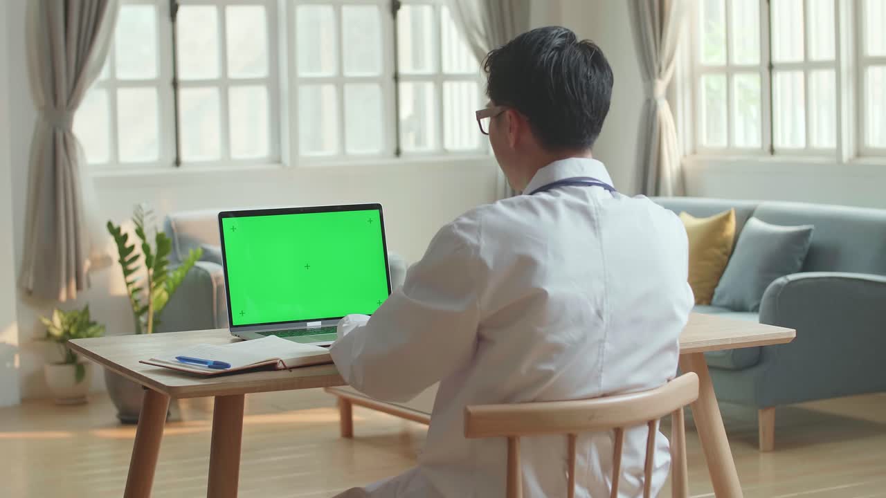 Man Doctor Video Call On Laptop Computer With Green Screen And Talking To Patient Online From Medical Office, Video In 4K
