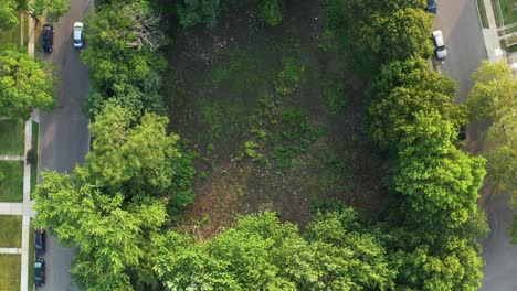 Rise-up-crane-shot---rotate-clockwise-over-a-local-water-runoff-with-light-car-traffic-circling