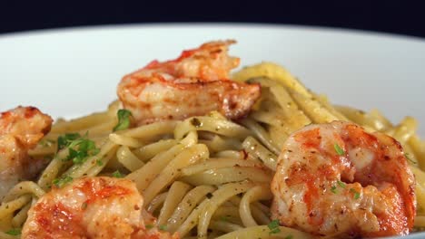 fresh parsley being sprinkled over shrimp pasta dish