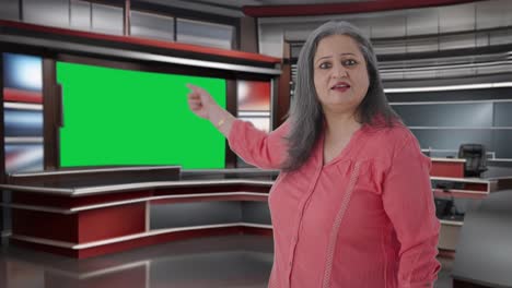 Angry-Indian-senior-female-journalist-pointing-towards-Green-screen