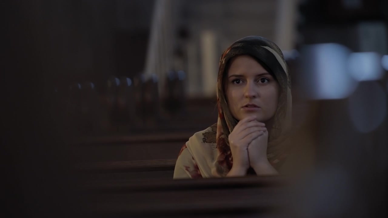 Giovane donna che prega in chiesa