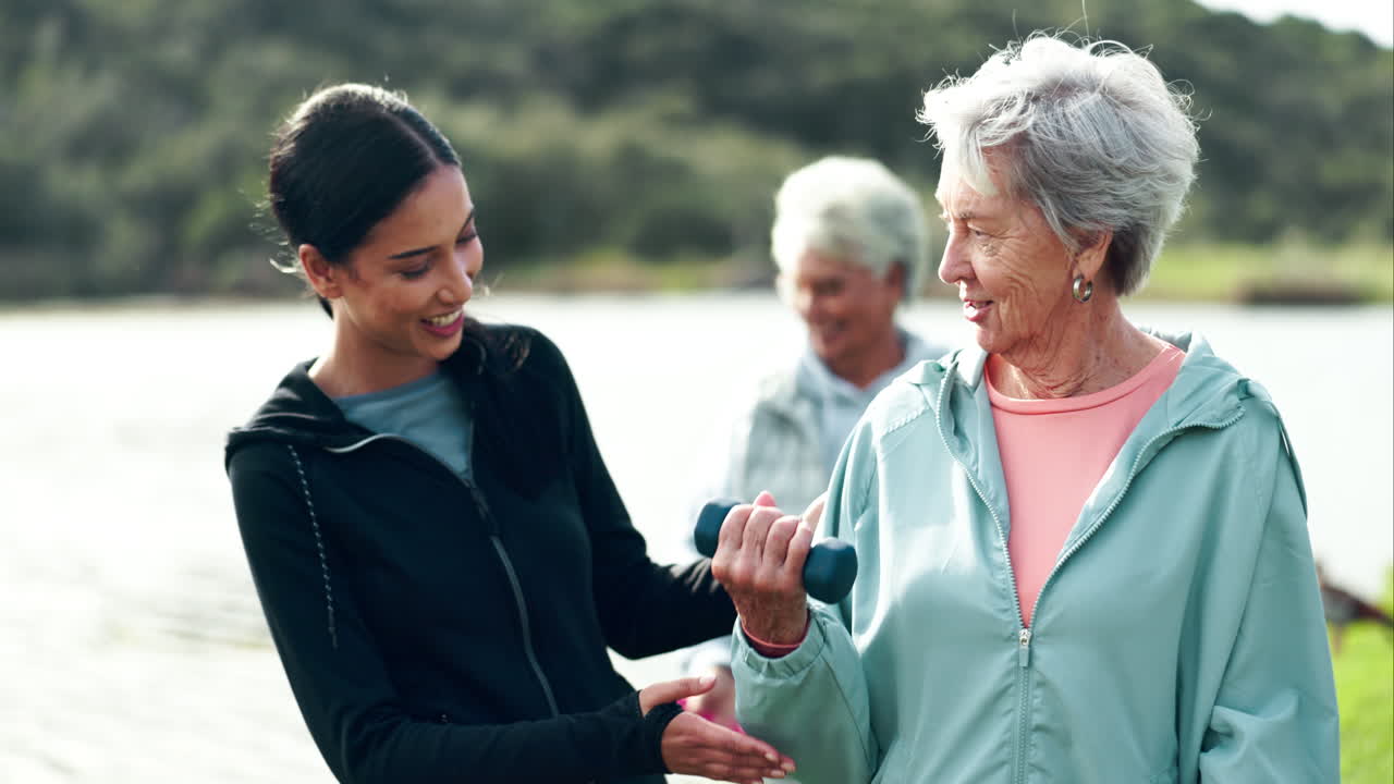 Elderly woman exercising with personal trainer outdoors
