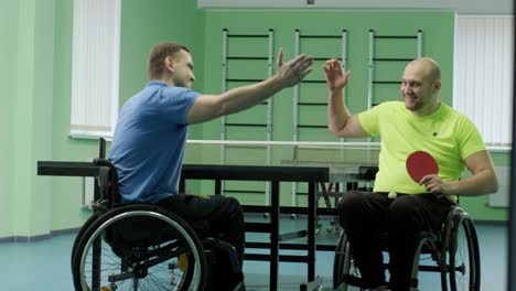 a man in a wheelchair plays ping pong. people with disabilities play table tennis. rehabilitation of the disabled. paralympic sport.