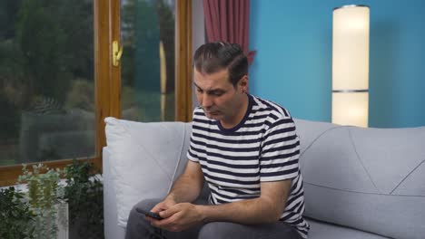 man smiling at phone message.