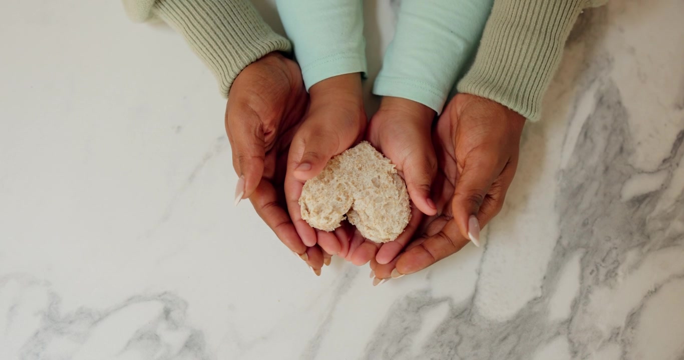 Mother and Child Holding Heart-Shaped Bread Together
