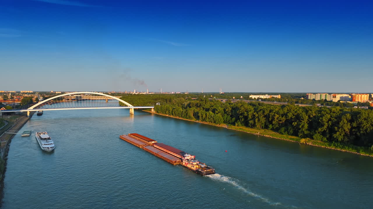 Water vehicles move by the Danube on sunny day. View on the Appolo bridge in Bratislava, Slovakia