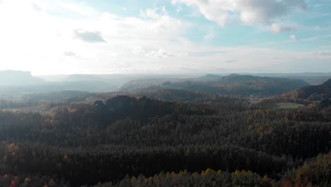 Hazy-sunny-sky-above-mountain-forests-in-Saxon-Switzerland,-Germany