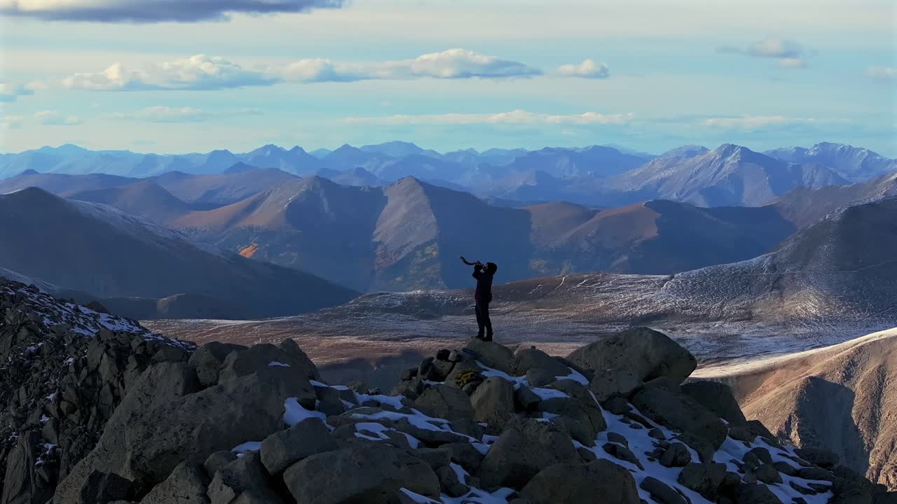 Shofar ram horn music blown from hiker top of Rocky Mountains summit Jewish Christian tradition Walls of Jericho Mt Mount Shavano Elbert Huron Peak Central Colorado aerial drone sunset snow static