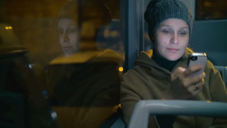 young woman typing sms during bus ride