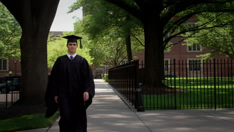 a young graduate walks on a university campus
