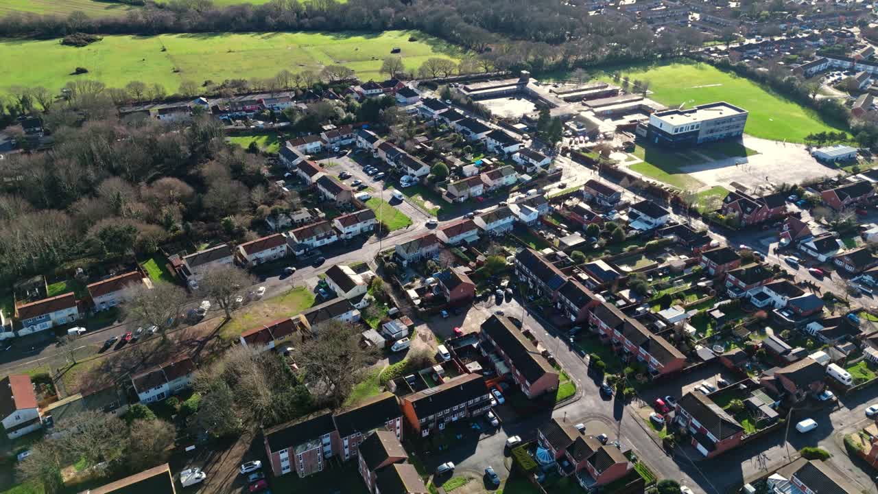 Luftaufnahme einer Landschaft mit einer Drohne über Sholing, einer Region in Southampton, England. Eine wunderschöne Vorstadt mit roten Häusern, Gärten, stark befahrenen Straßen mit Verkehr und Autos während eines wunderschönen Wintersonnenuntergangs
