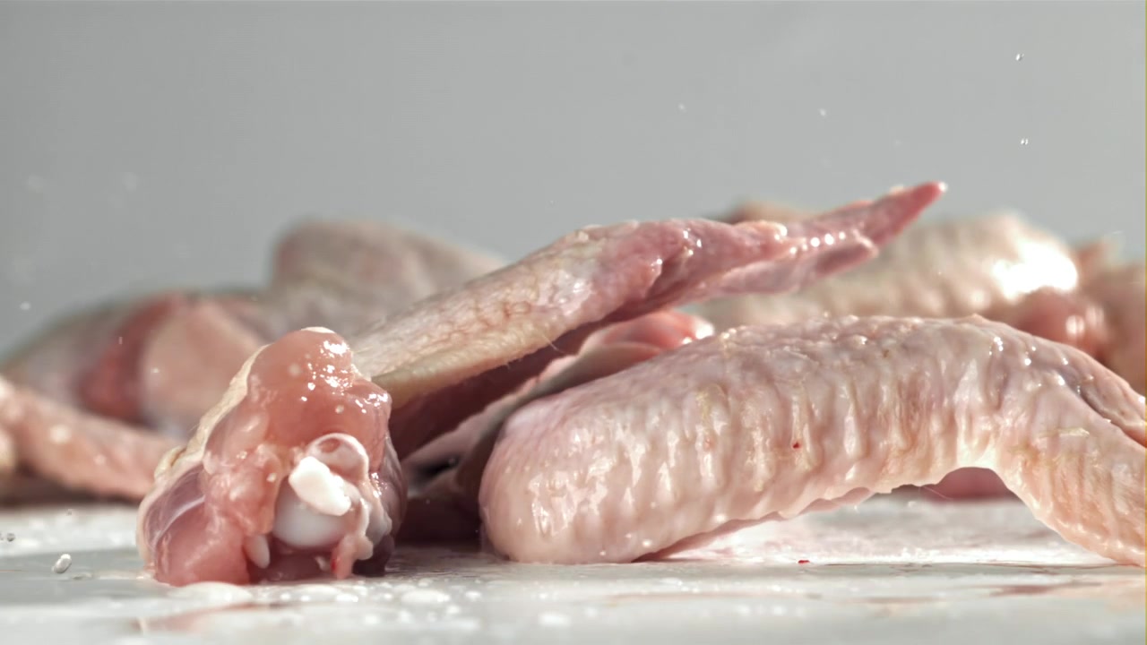 Ala di pollo fresca e cruda che cade al rallentatore