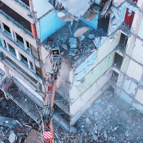 demolishing vehicle breaks and throws down the parts of ruined house. dismantling the old building with the help of machinery. view from above