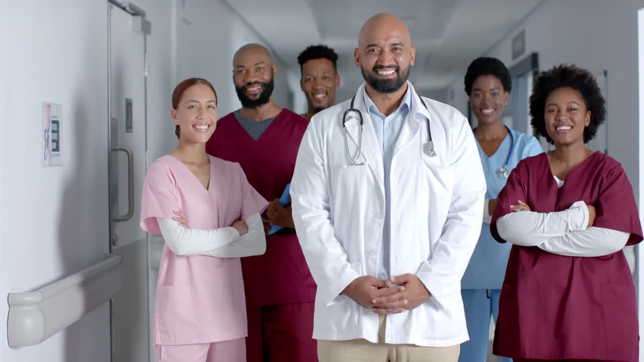 Happy diverse doctor smiling in hospital corridor, slow motion