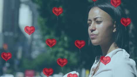 multiple red heart shapes balloons floating against woman drinking coffee on the street