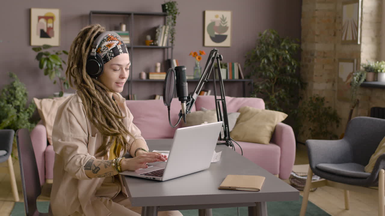 kvinna med dreadlocks som spelar in en podcast med hörlurar