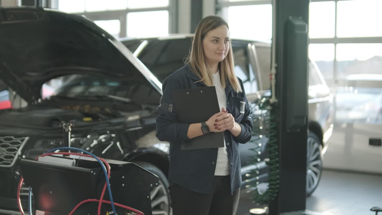 gerente femenina discutiendo la reparación de vehículos con el mecánico en el taller de reparación de automóviles