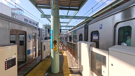 a train arrives and departs at a tokyo station, showcasing urban transportation. bright daylight illuminates the modern platform