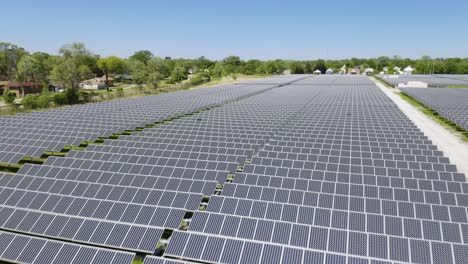 el vuelo aéreo hacia atrás revela miles de paneles solares que producen energía renovable limpia para alimentar la tierra
