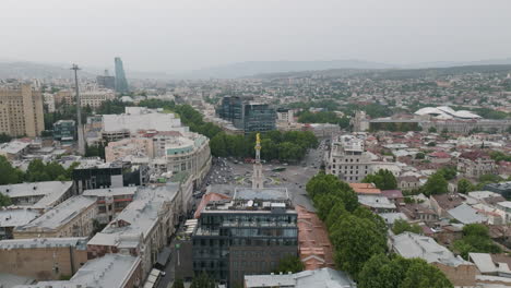 Dolly-in-aerial-shot-of-foggy-cityscape-of-Tbilisi-and-the-Freedom-Square