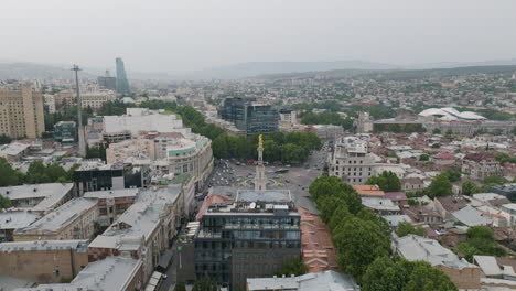 dolly en una toma aérea del paisaje urbano nebuloso de tbilisi y la plaza de la libertad