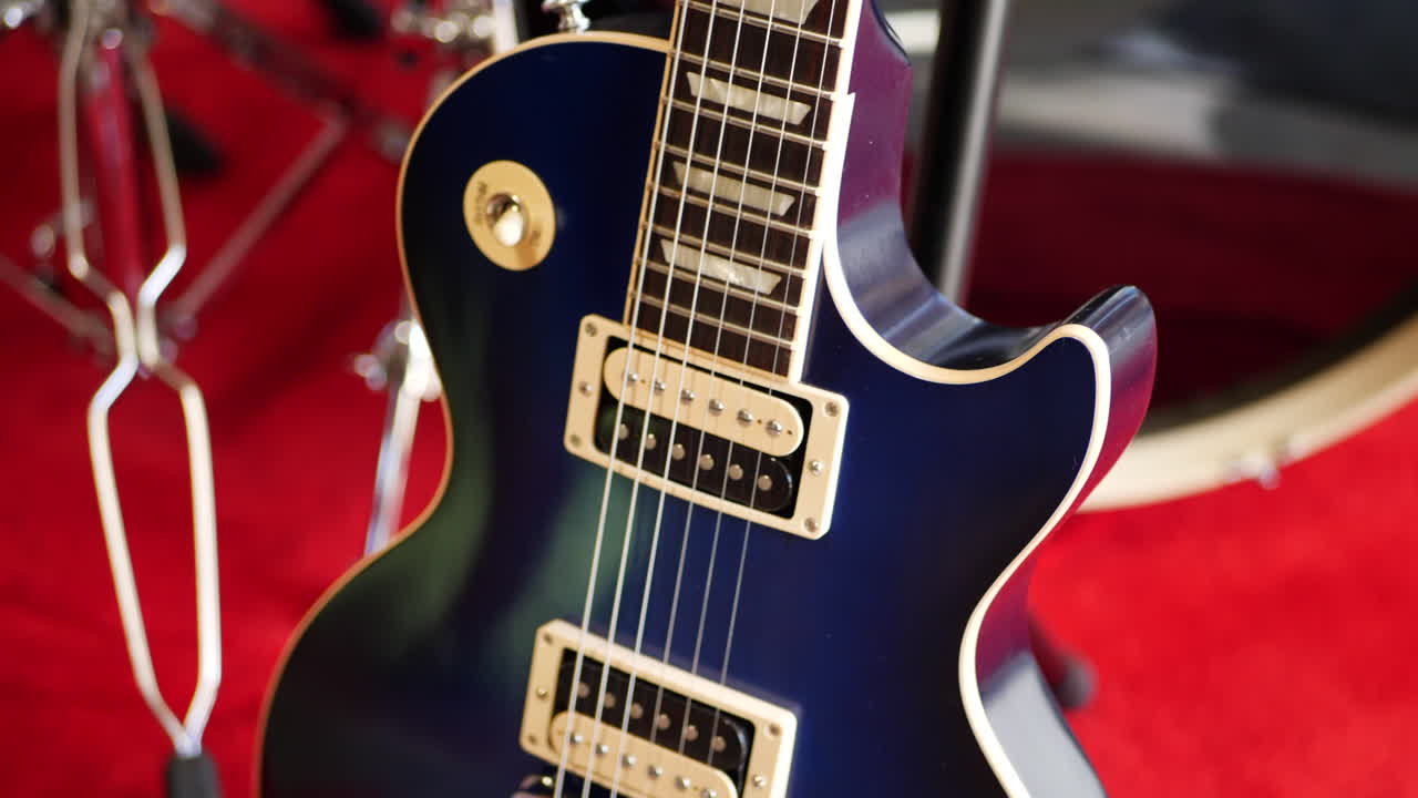 Rock and roll garaj grubu konseptinde bir konser sahnesinde duran vintage mavi bir elektro gitar