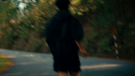 man running on a road through forest