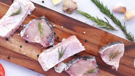 filete de pescado crudo en una tabla de corte de madera con ingredientes