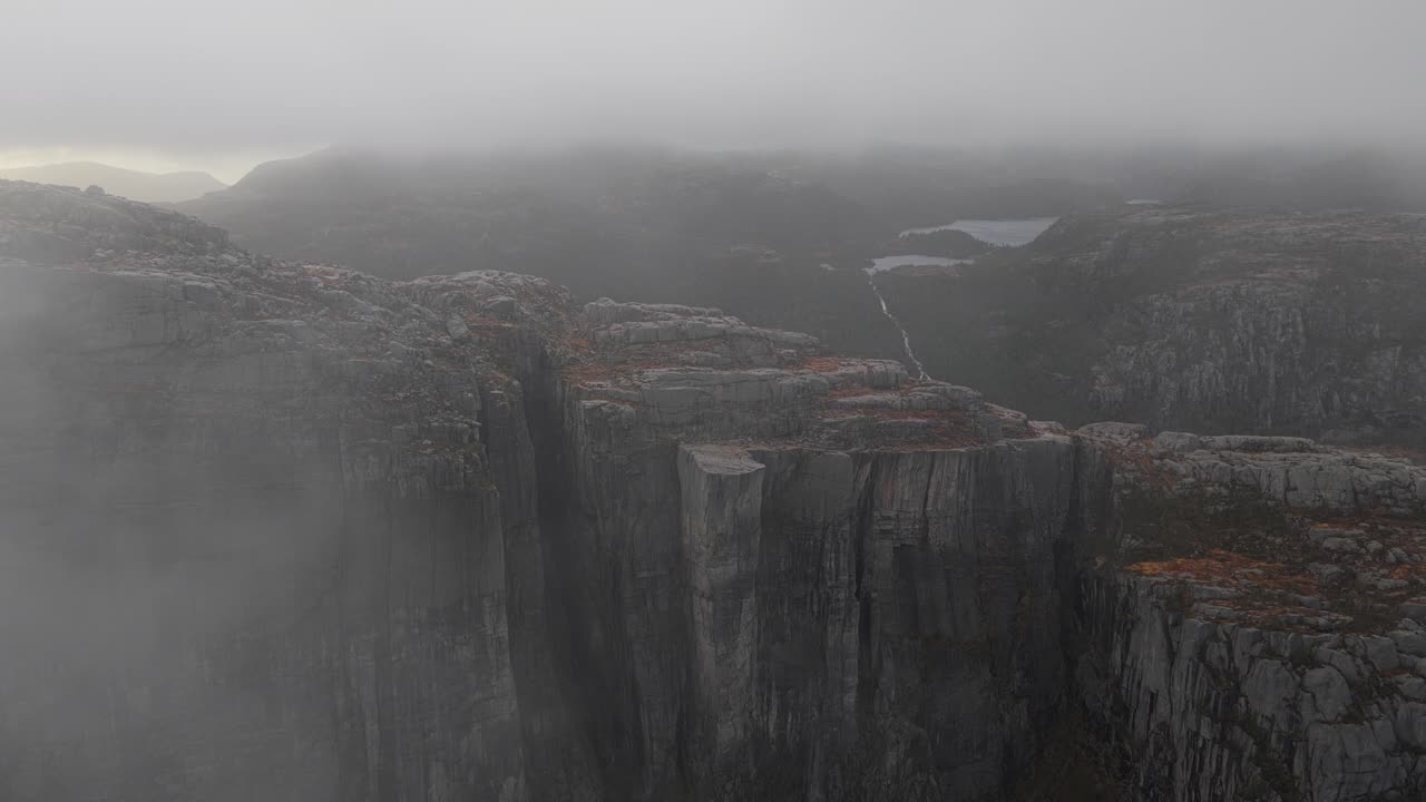 Meseta rocosa de Preikestolen con cielo nublado durante el atardecer, vista aérea.
