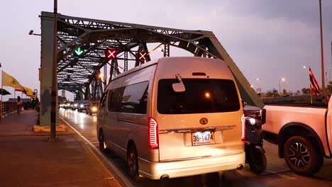 vehicles and motorcycles crossing a busy bangkok bridge