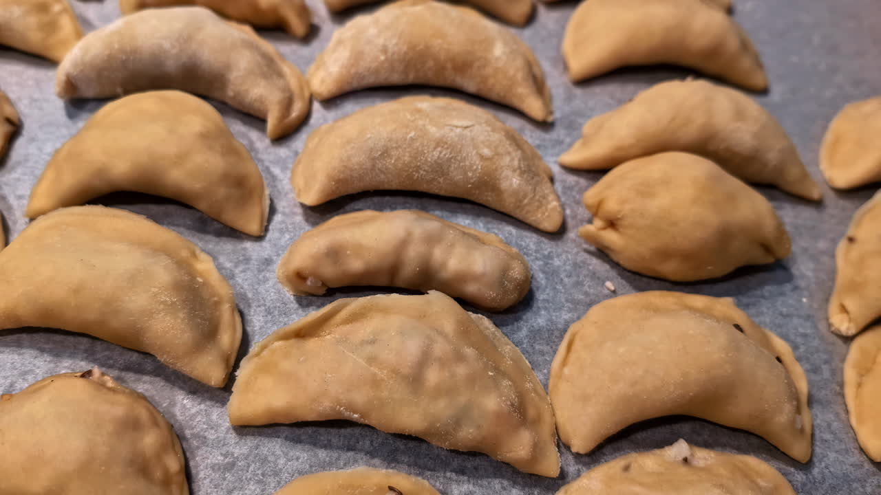 Freshly baked empanadas arranged on a baking sheet, ready to serve
