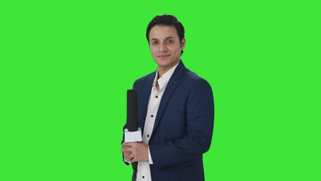 Portrait-of-Happy-Indian-reporter-standing-crossed-hands-Green-screen