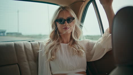 woman traveler riding back seat vintage auto closeup. girl travelling with joy