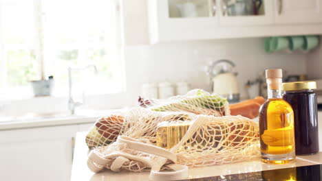 shopping in net lying on counter in sunny kitchen at home, slow motion