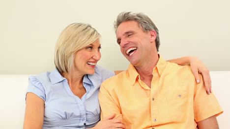 Couple-laughing-together-on-the-couch