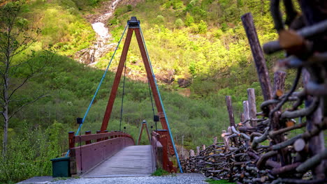 Zeitrafferaufnahmen-Von-Touristen,-Die-Fotos-Machen,-Während-Sie-Tagsüber-Auf-Einer-Holzbrücke-Entlang-Eines-Hügeligen-Geländes-Gehen