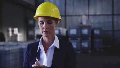 Female-warehouse-manager-checking-stock-in-storeroom-4k